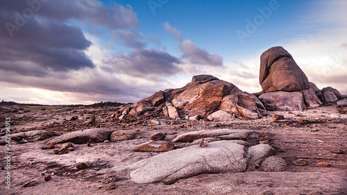 PAISAJE DE ROCAS EN EMBALSE SECO CON HORIZONTE DE CIELO AZUL Y NUBES photo