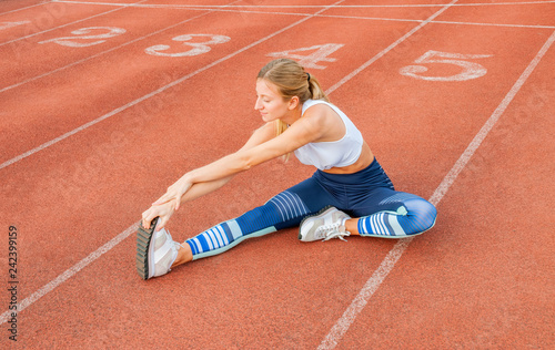 Fitness woman stretching legs before run on outdoors