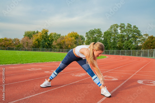 Fitness woman stretching legs before run on outdoors