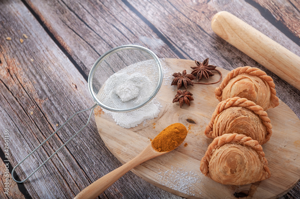 Traditional curry puffs stuffed chicken on wooden table as background