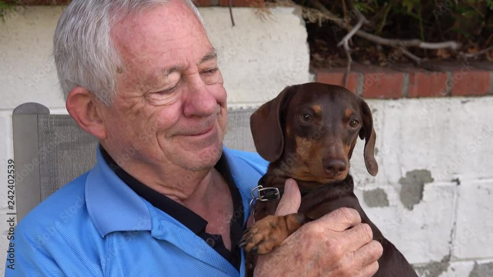 Senior man holding and cuddling his dog