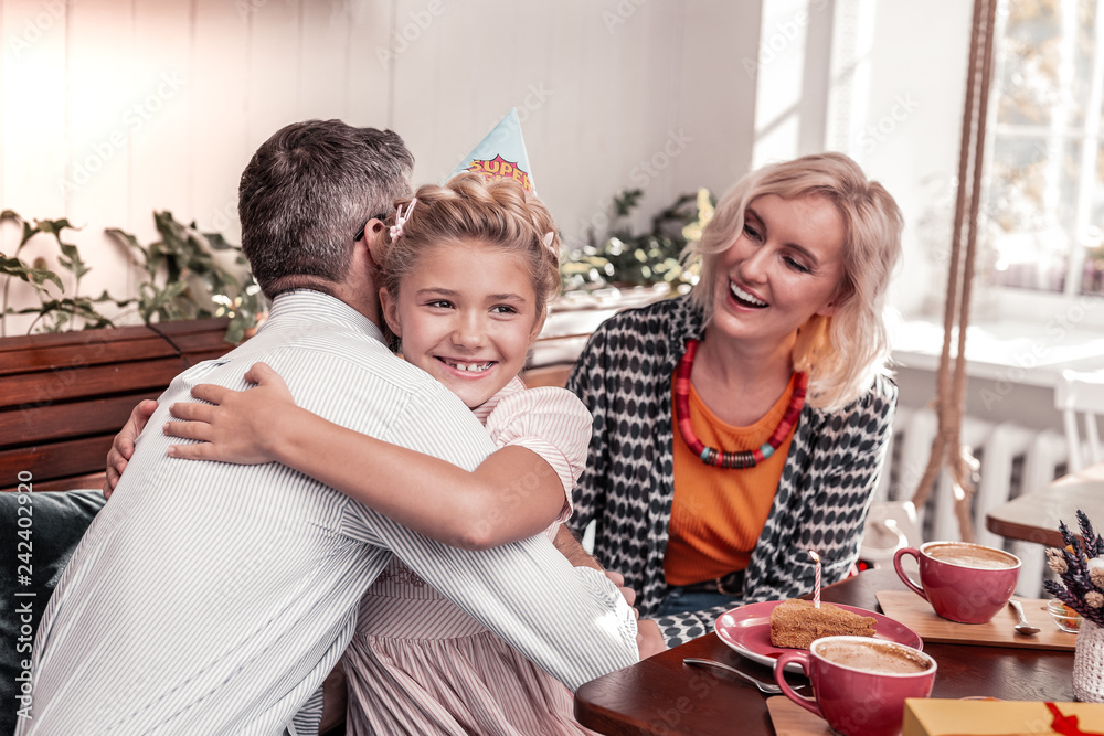 Cheerful positive girl hugging her beloved father Cheerful positive girl hugging her beloved father
