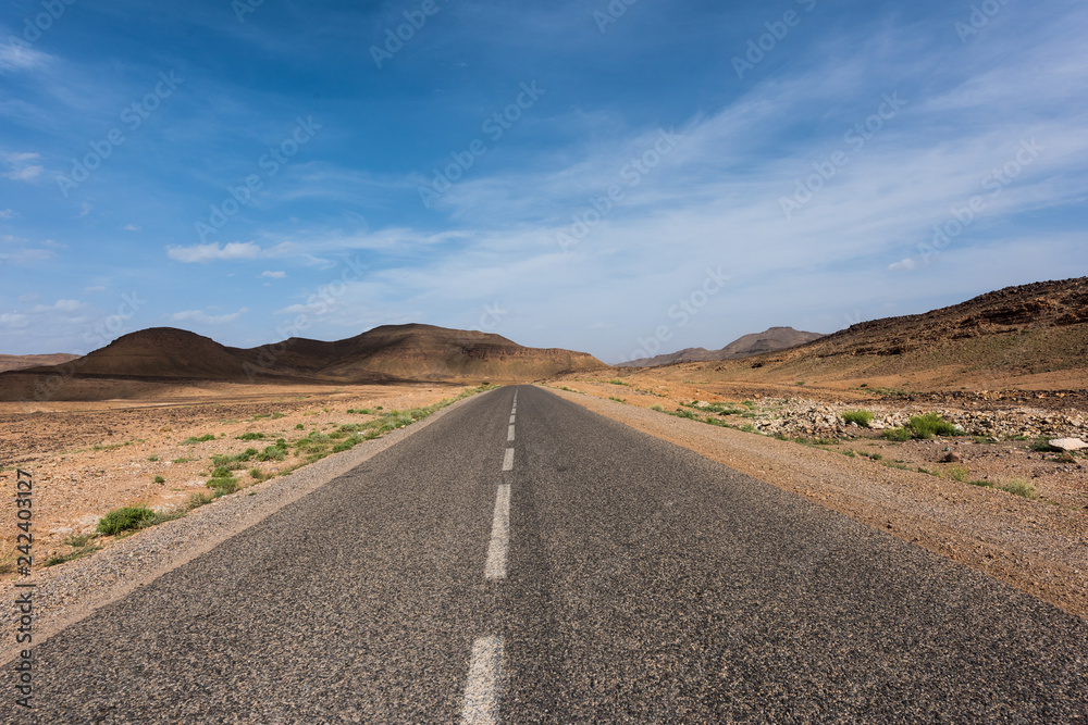 Moroccan highway featuring a rocky desert landscape on a road trip from Marrakesh to Merzouga Moroccan highway featuring a rocky desert landscape on a road trip from Marrakesh to Merzouga