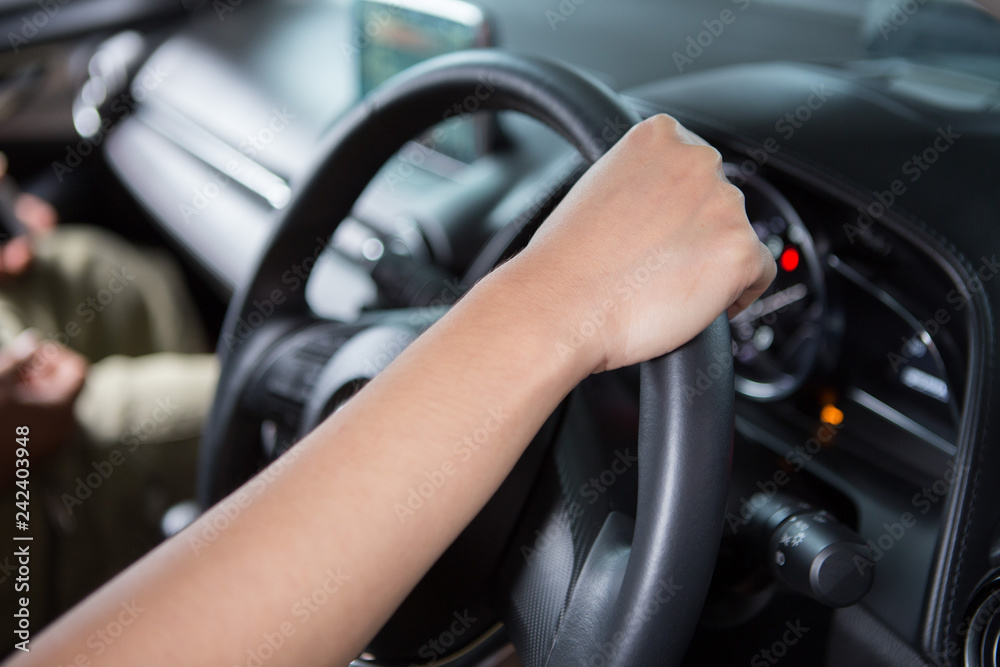 Woman hand holding steering wheel