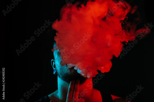 Guy blowing a lot of smoke out of his mouth.