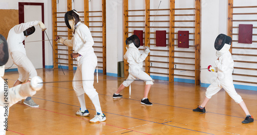 Young fencers training with coach