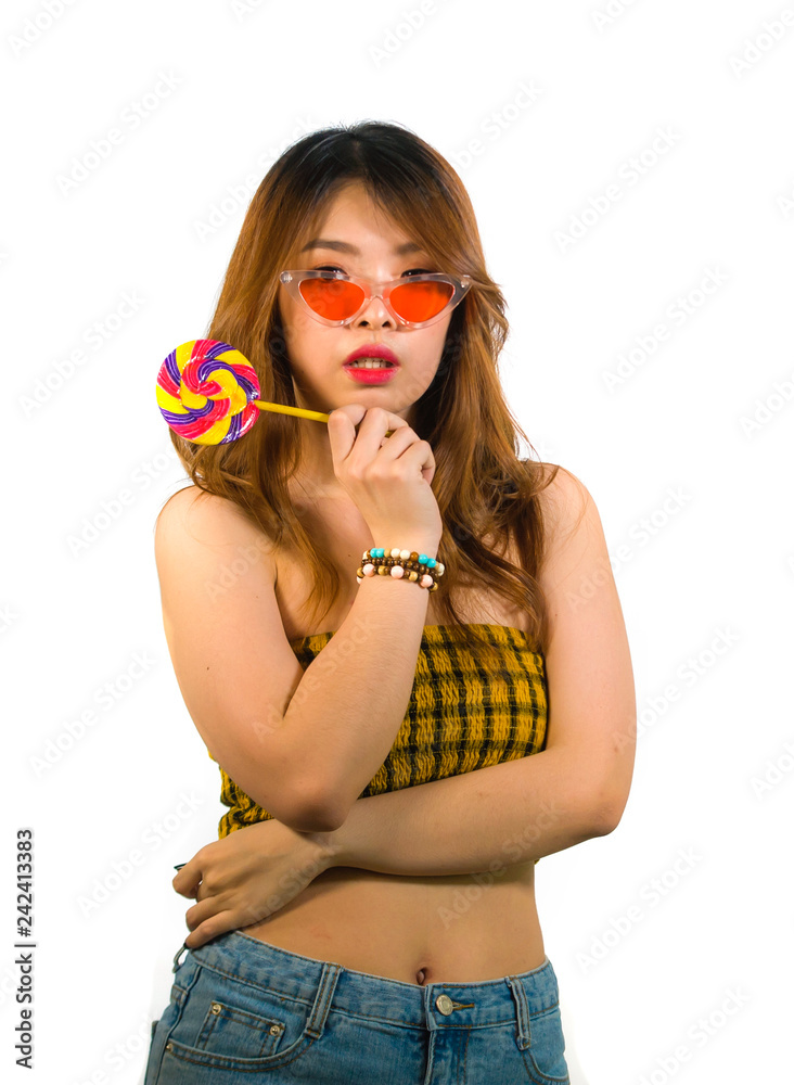 portrait of young happy and sexy Asian Korean girl in cool fashion sunglasses eating lollipop candy posing naughty teasing cheerful isolated on white background portrait of young happy and sexy Asian Korean girl in cool fashion sunglasses eating lollipop candy posing naughty teasing cheerful isolated on white background