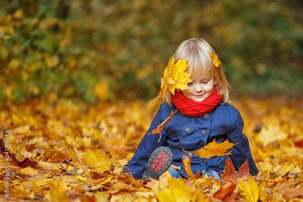 Little autumn funny girl sitting in autumn park. Selective focus, copy space. Little autumn funny girl sitting in autumn park. Selective focus, copy space.