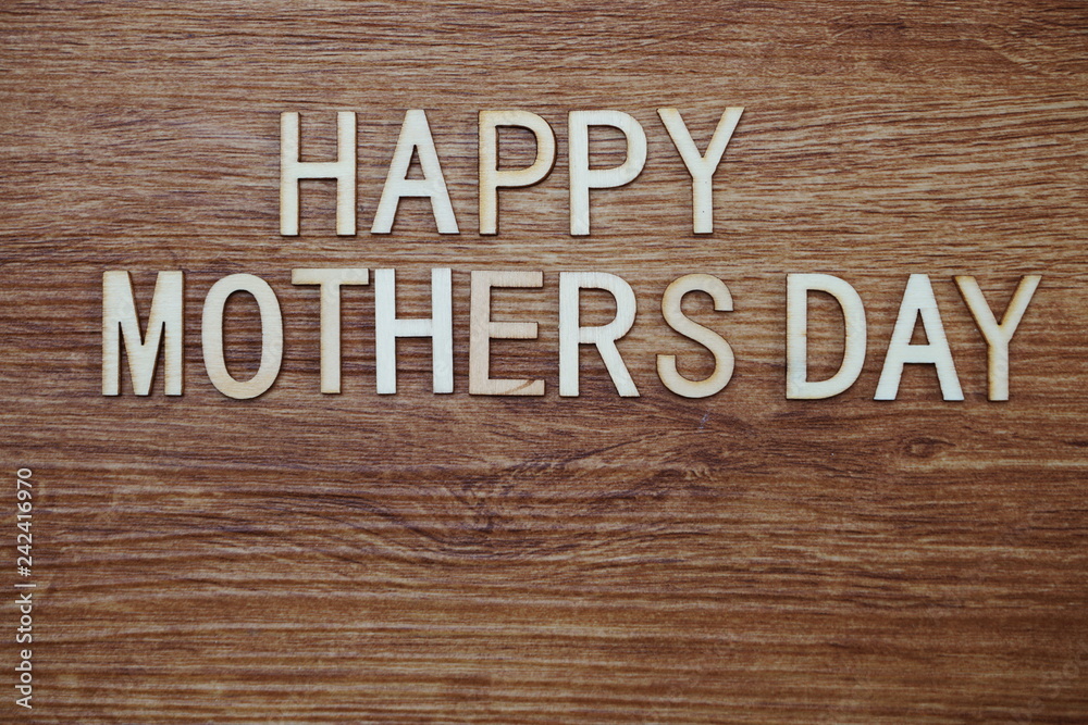 Happy Mothers Day text message on wooden background