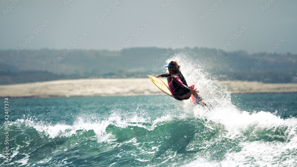 Surfer flies on the wave in the ocean