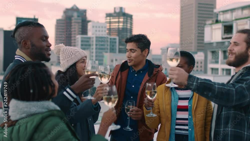 cheerful group of friends enjoying rooftop party celebration drinking alcohol making toast having fun social gathering celebrating weekend of friendship at sunset