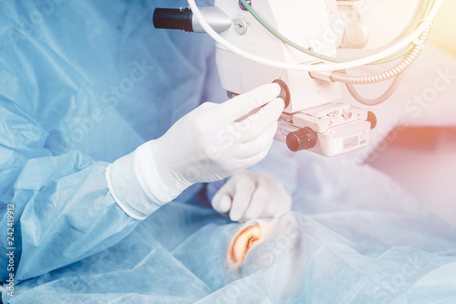 Lasik treatment. Laser vision correction. Doctor examines fundus in microscope, patient under sterile cover.