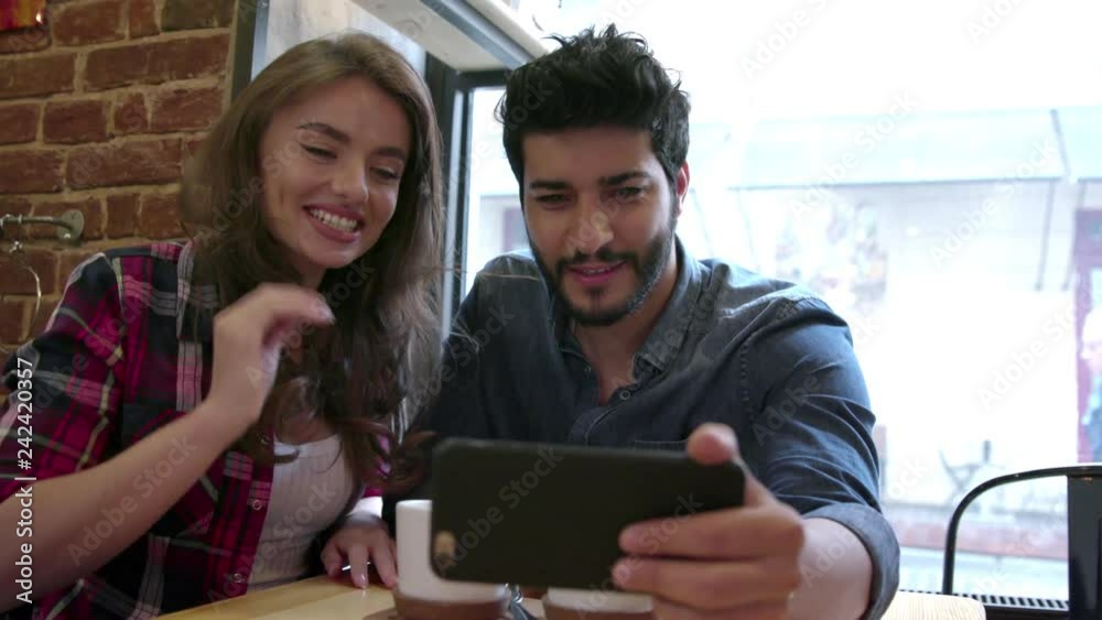 Video Calling. Happy Couple Using Phone For Video Call In Cafe Video Calling. Happy Couple Using Phone For Video Call In Cafe