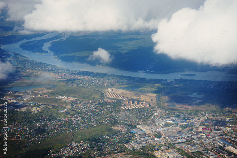 Obraz premium Landscape, the surface of the earth through the clouds from an airplane window.