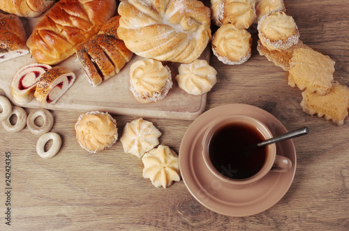 Cup of coffee and sweet pastry on a wooden table