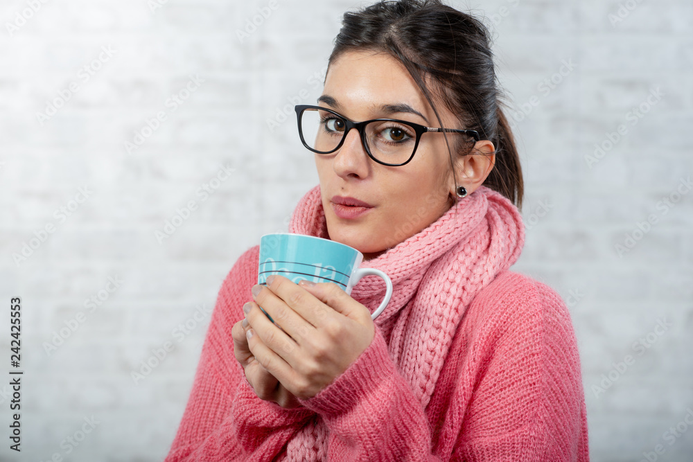 young brunette woman dressed in pink drinking a cup of tea young brunette woman dressed in pink drinking a cup of tea