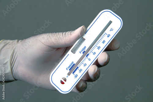 Doctor's hand holding thermometer 
