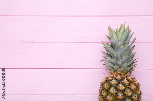Ripe pineapple on a pink background with copy space
