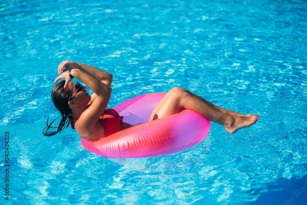 Sexy woman in bikini enjoying summer sun and tanning during holidays in pool. top view