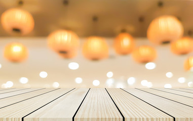 abstract blurred orange color of chinese lantern hang on ceiling and cream wood tabletop perspective for show promote product on display , celebration new year concept