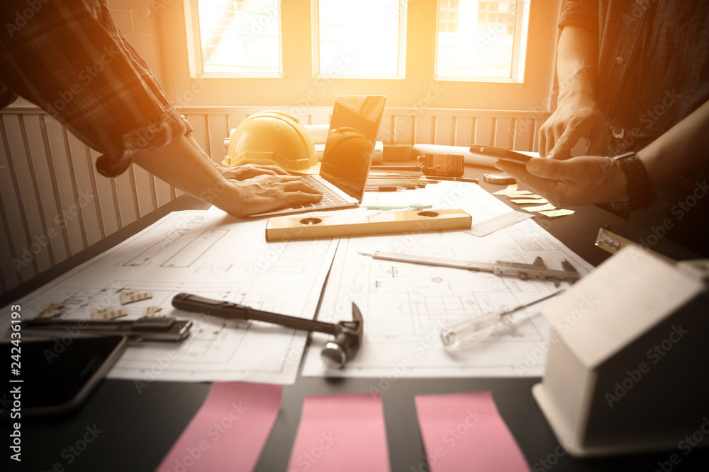 Concept Agreement between the employer and architect Nick and desk of Architectural project in construction site or office building with morning light Concept Agreement between the employer and architect Nick and desk of Architectural project in construction site or office building with morning light