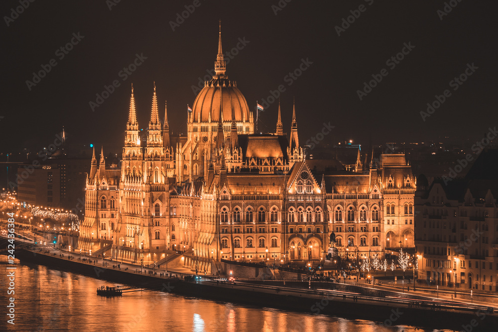 Illuminated Budapest parliament building at night with dark sky and reflection in Danube river Illuminated Budapest parliament building at night with dark sky and reflection in Danube river