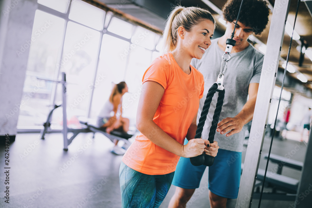 Young beautiful woman doing exercises with personal trainer Young beautiful woman doing exercises with personal trainer