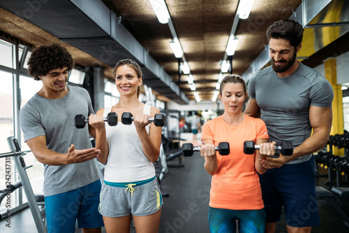 Young beautiful women doing exercises with personal trainers