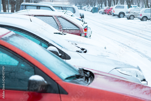 Parked cars on the street covered in snow