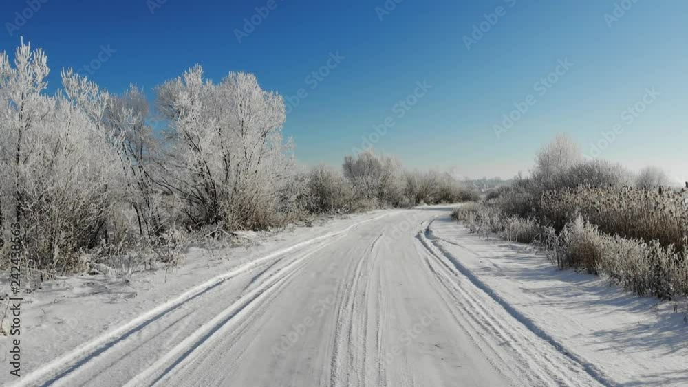 Smooth flight ahead above a snowy road. Trees and shrubs are covered with snow, winter beauty Smooth flight ahead above a snowy road. Trees and shrubs are covered with snow, winter beauty