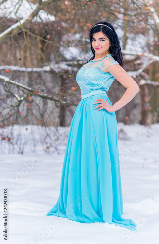 Greece woman in blue long romantic dress at snowy day, femininity and grace concept, winter fairytale 