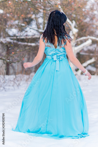 Greece woman in blue long romantic dress at snowy day, femininity and grace concept, winter fairytale 