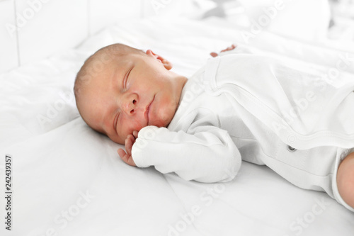 Noworodek. Pierwsze dni na świecie, noworodek śpi w łóżeczku.