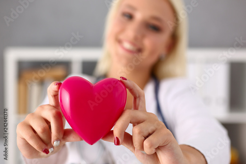 Beautiful smiling blond female doctor hold in