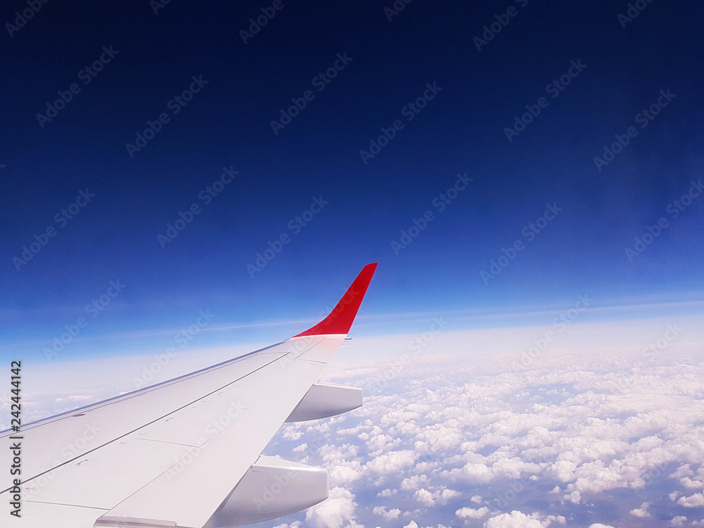 Fototapeta premium wing of an airplane flying above clouds