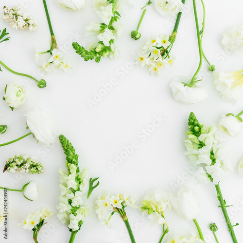 Floral frame of white flowers on white background. Flat lay, top view. © artifirsov