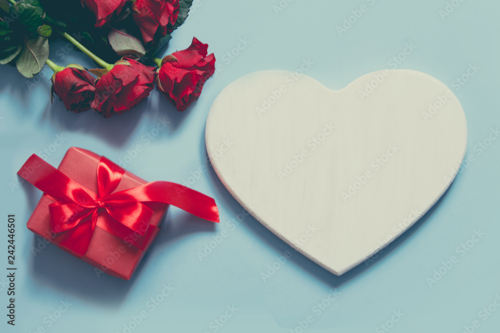 Valentine's card with space for text, giftbox, bouquet red roses on blue. Copy space. View from above. Valentine's card with space for text, giftbox, bouquet red roses on blue. Copy space. View from above.