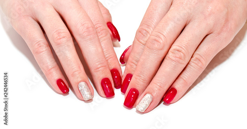 Woman's nails with beautiful red manicure fashion design with gems isolated