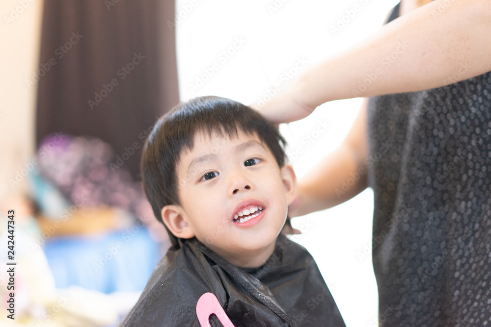 Grandmother is cutting hair of her grandson at home. Grandmother is cutting hair of her grandson at home.