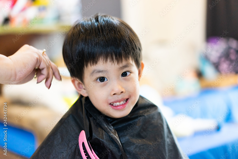 Grandmother is cutting hair of her grandson at home. Grandmother is cutting hair of her grandson at home.