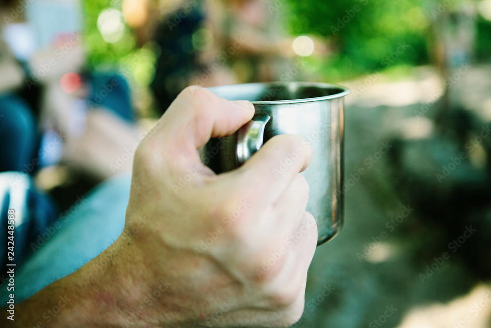 Man is holding camping cup . Man is holding camping cup .