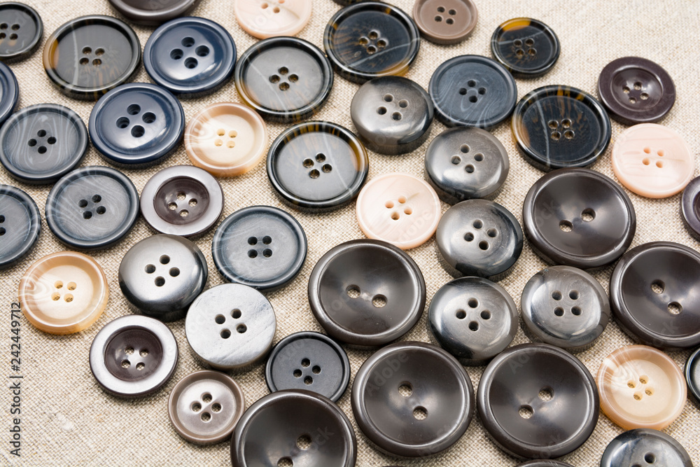 Large multi-colored sewing buttons on linen natural fabric Large multi-colored sewing buttons on linen natural fabric