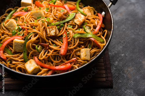 Schezwan hakka noodles with paneer or cottage cheese. Served in a bowl. selective focus
