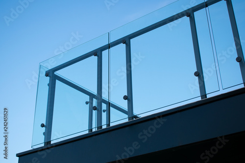 Tempered glass balcony railing. Sky blue background.