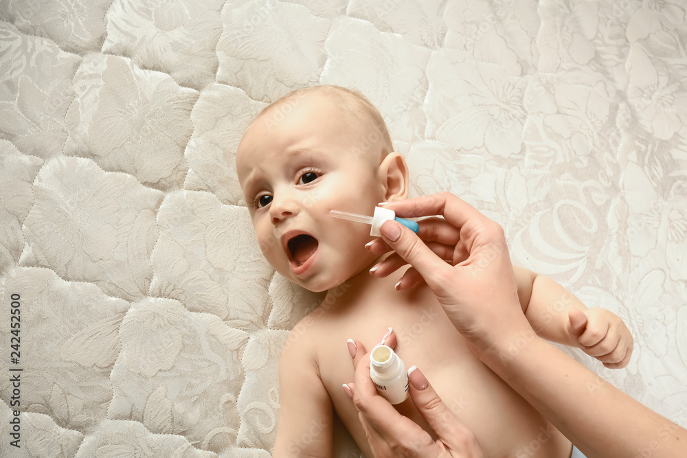 Doctor hand cleans baby's nose. Newborn baby gets nose drops. Baby care concept Doctor hand cleans baby's nose. Newborn baby gets nose drops. Baby care concept