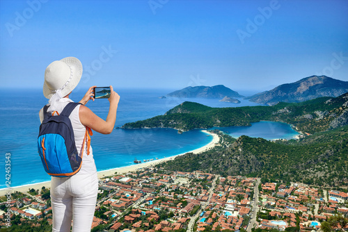 Oludeniz or Olu deniz coast from air, Fethiye, Turkey A tourist woman taking photo of Kayakoy village with phone.