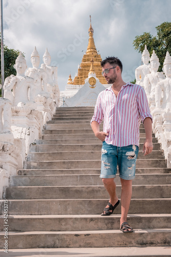 young couple on vacation in Myanmar visiting a old historical whitewashed white temple Buddhism in Mandalay ,  Mya Thein Tan Pagoda  photo