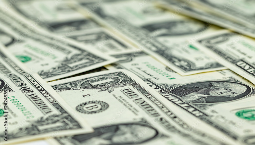 One-dollar bills are on the table in an even layer One-dollar bills are on the table in an even layer