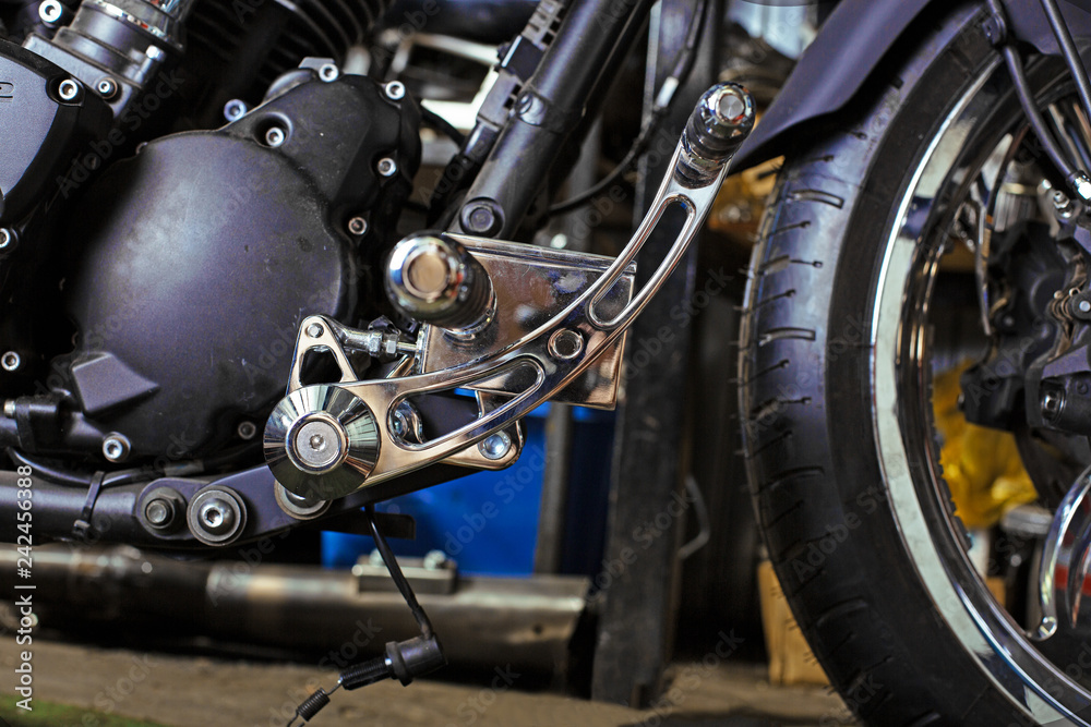 Cropped close up shot of beautiful and custom made motorcycle in the workshop Cropped close up shot of beautiful and custom made motorcycle in the workshop