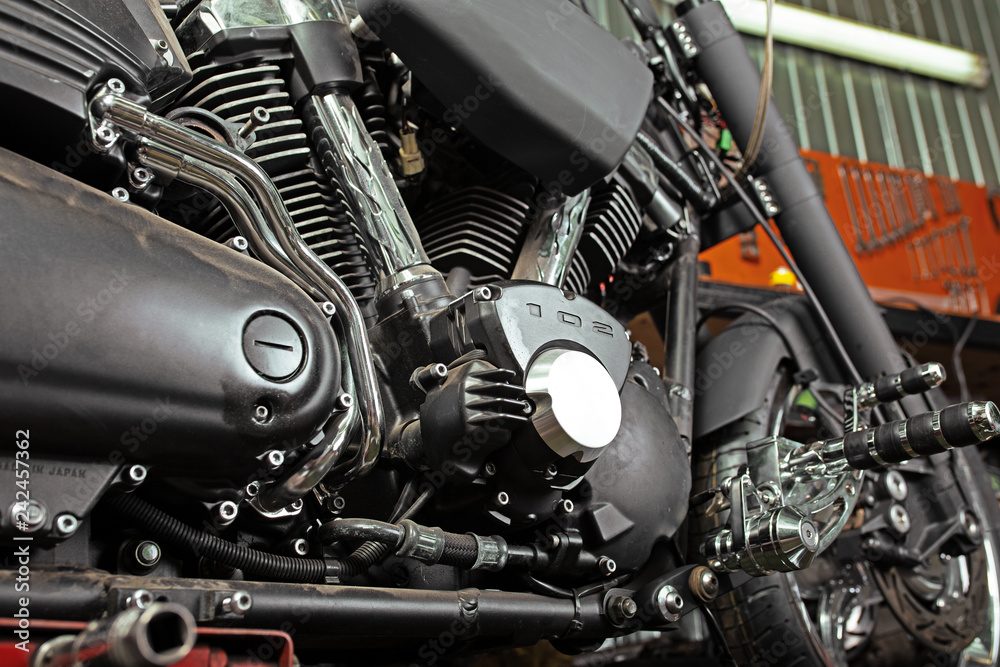 Cropped close up shot of beautiful and custom made motorcycle in the workshop Cropped close up shot of beautiful and custom made motorcycle in the workshop